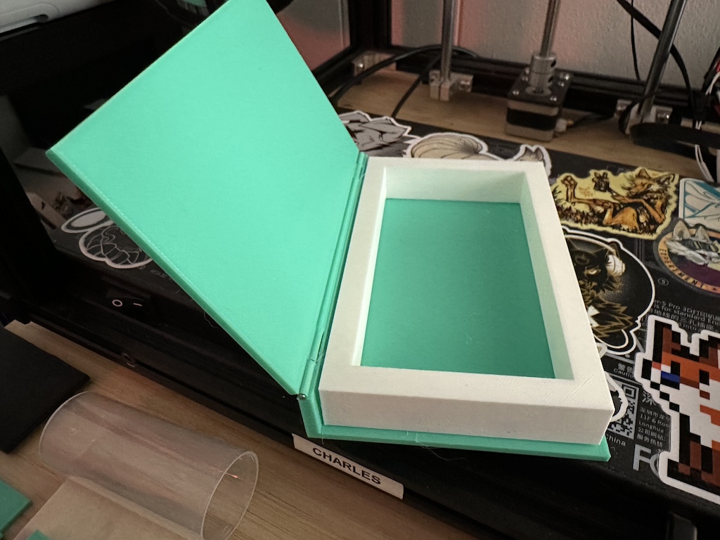 photograph of an open, teal, plastic, hollow book