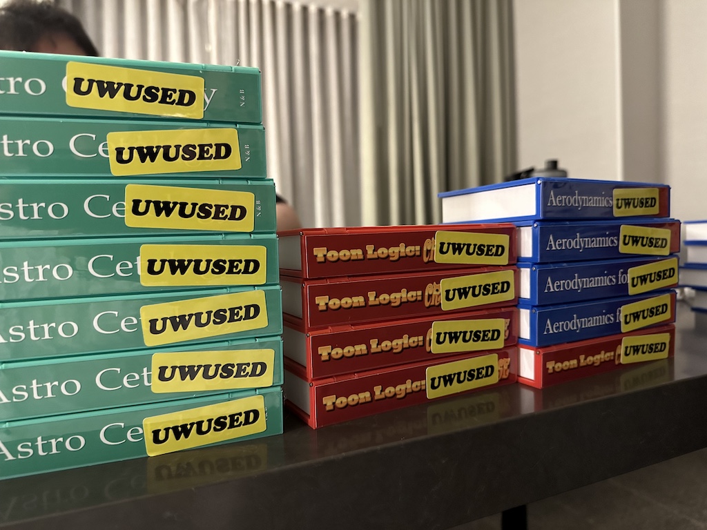 photograph of book spines with ‘uwused’ stickers